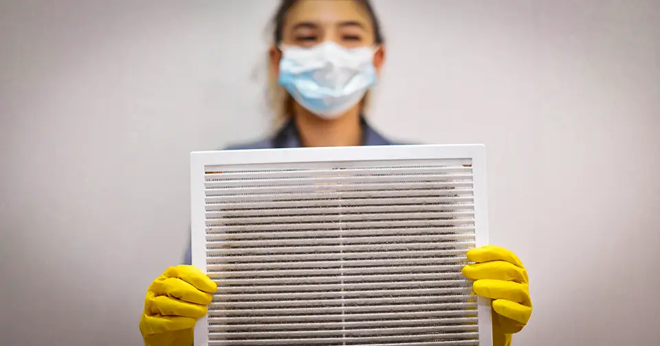 A girl is changing out a dirty HVAC filter.